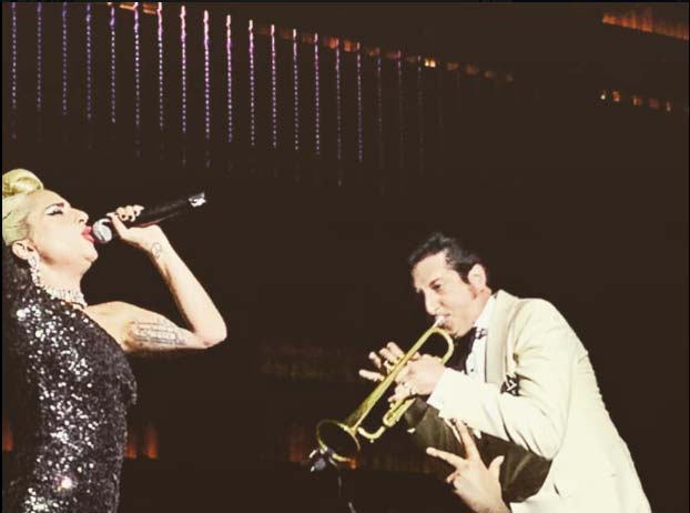 Lady Gaga singing and performing while Brian Newman accompanies on trumpet
