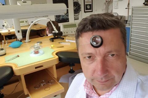 A professional taking selfie while repairing watch